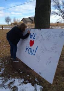 woman writing message of support on board